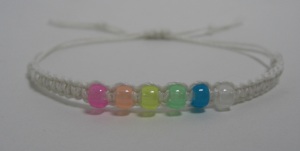 Handmade knotted macrame adjustable bracelet made with white bamboo cord and high quality glow pony beads.